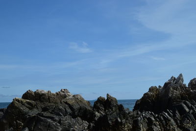 Low angle view of rocks against blue sky