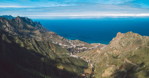 Panoramic view of sea and mountains against sky