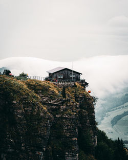 House by tree and mountain against sky