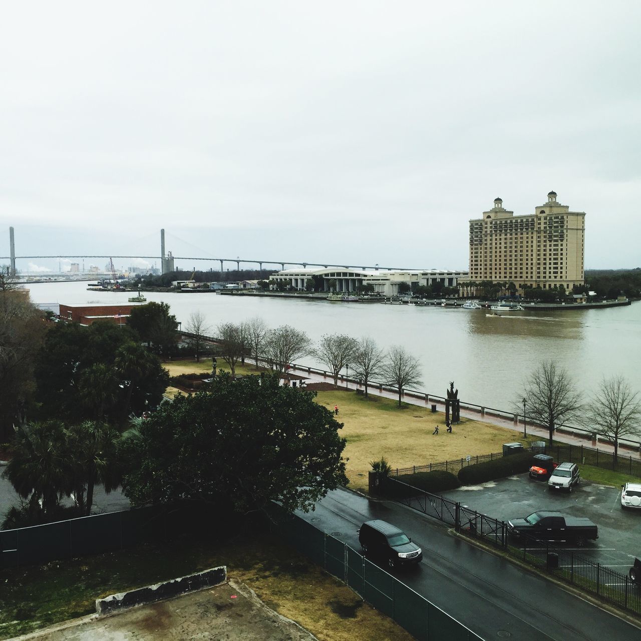 architecture, built structure, building exterior, water, transportation, river, bridge - man made structure, city, sky, connection, road, day, high angle view, street, railing, incidental people, car, outdoors, tree, mode of transport