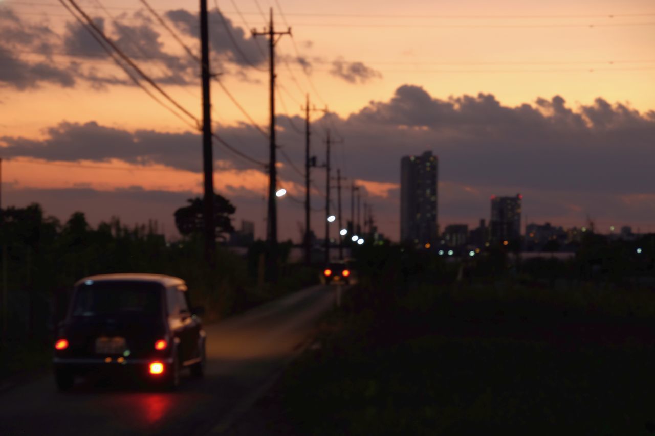 CARS ON ROAD IN CITY AGAINST SKY