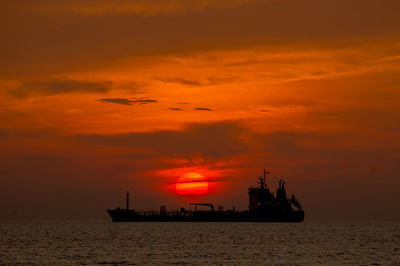 Ship in sea against sky during sunset