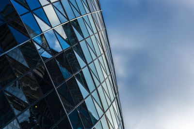 Low angle view of glass building against sky