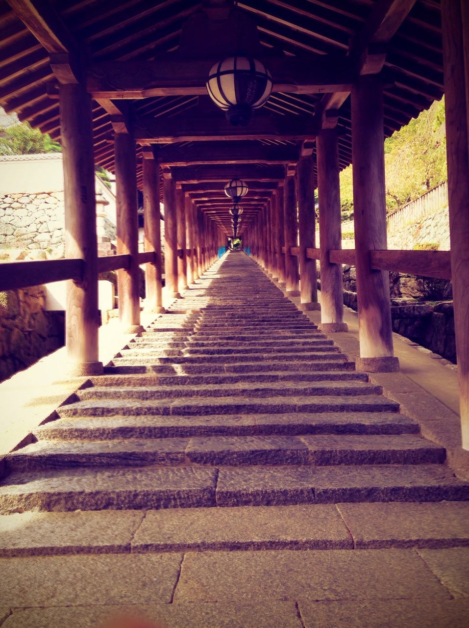 the way forward, diminishing perspective, built structure, architecture, vanishing point, in a row, sunlight, long, shadow, wood - material, architectural column, railing, empty, no people, day, walkway, outdoors, narrow, pattern, absence