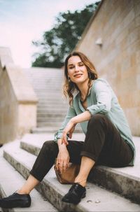 Portrait of smiling young woman sitting outdoors