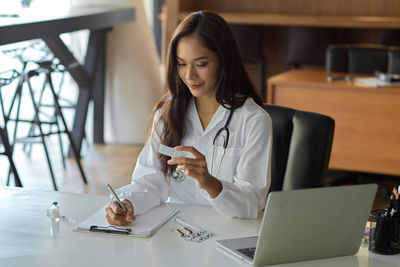 Doctor writing on clipboard at hospital