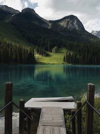 Scenic view of lake by mountains against sky