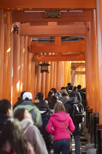 Rear view of people standing in front of building