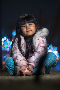 Portrait of cute girl sitting outdoors