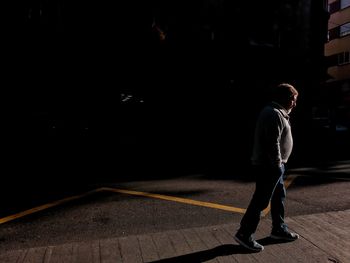 Side view of man standing at night
