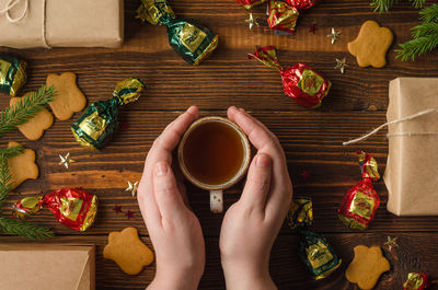 High angle view of woman holding coffee cup on table