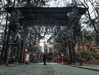 Rear view of woman walking by temple