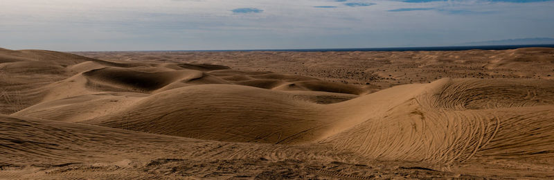 Sand dunes in desert against sky