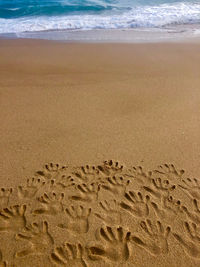 High angle view of footprints on sand at beach