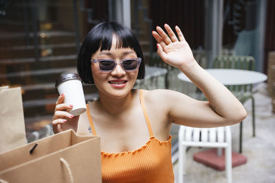 Portrait of a smiling young woman holding camera