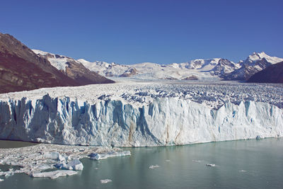 Scenic view of glacier against clear blue sky