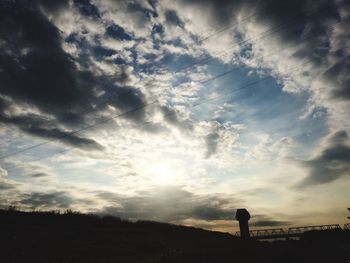 Silhouette of man against cloudy sky