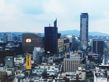 View of cityscape against cloudy sky