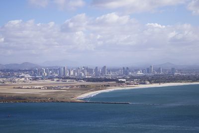 Aerial view of city buildings against cloudy sky