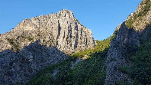 Panoramic view of rocky mountains against clear sky