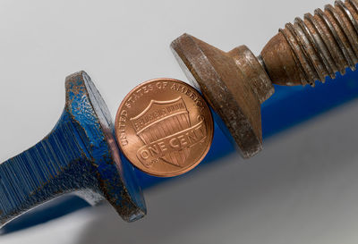 High angle view of coins on metal against white background