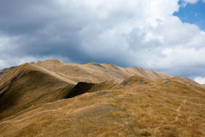 Scenic view of mountains against cloudy sky