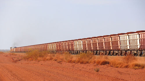 Abandoned train on field against clear sky