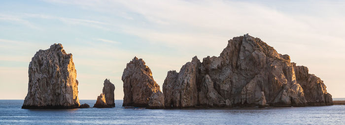 Panoramic view of rock formation in sea against sky