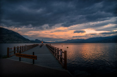 Pier over sea against sky at sunset