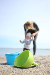 Midsection of woman on beach against clear sky