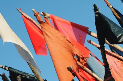 Low angle view of flags hanging against clear sky