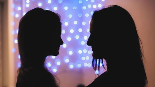 Portrait of silhouette woman against illuminated lights