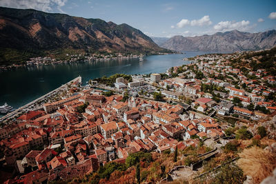 High angle view of townscape by lake against sky