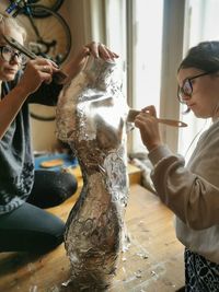 Women painting mannequin