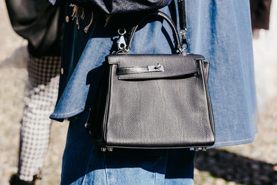 Midsection of woman holding bag