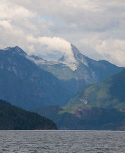 Scenic view of lake by mountains against sky