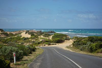 Road by sea against sky