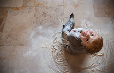 High angle portrait of cute boy playing with flour at home