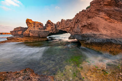 Rocks in sea against sky