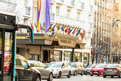 Traffic on road by buildings in city