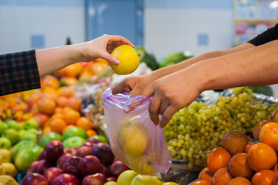 Woman buying fresh vegetables at street market.