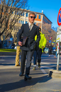 Full length of man standing on road in city