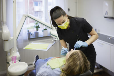 Female dentist with patient in office