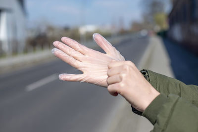 Midsection of person with umbrella on road in city