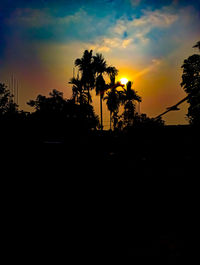 Silhouette palm trees against sky during sunset