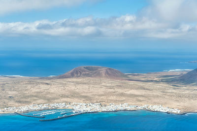 Aerial view of sea and mountains against sky