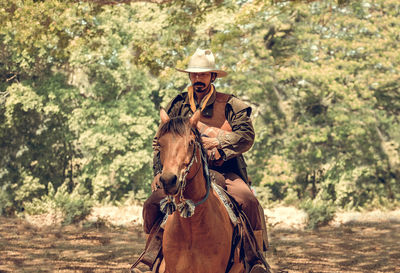 Man riding horse in forest