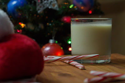 Close-up of drink by candy canes in glass on table