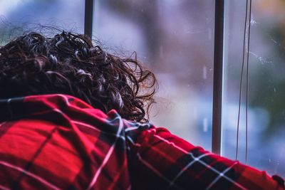 Rear view of woman looking through window