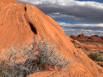 View of rock formations in desert against cloudy sky